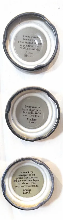 Three bottle caps with fortunes printed inside